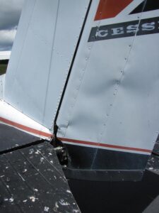 This wind damaged rudder will be an expensive repair. Properly secure your aircraft when parked